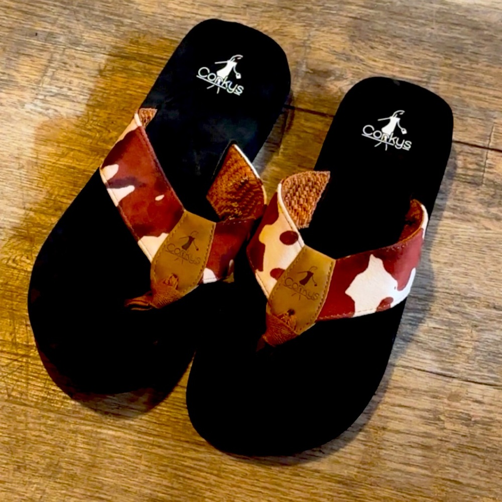 Corky’s Boutique cow print flip flops new without tags